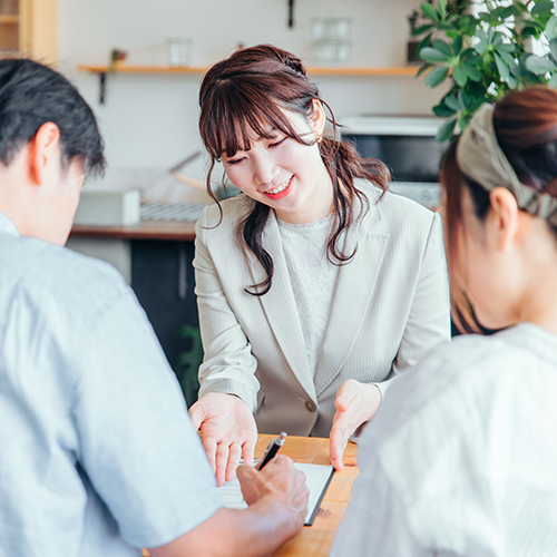 ビジネススーツを着た女性がお客様を相手にヒアリングしている様子のイメージ画像